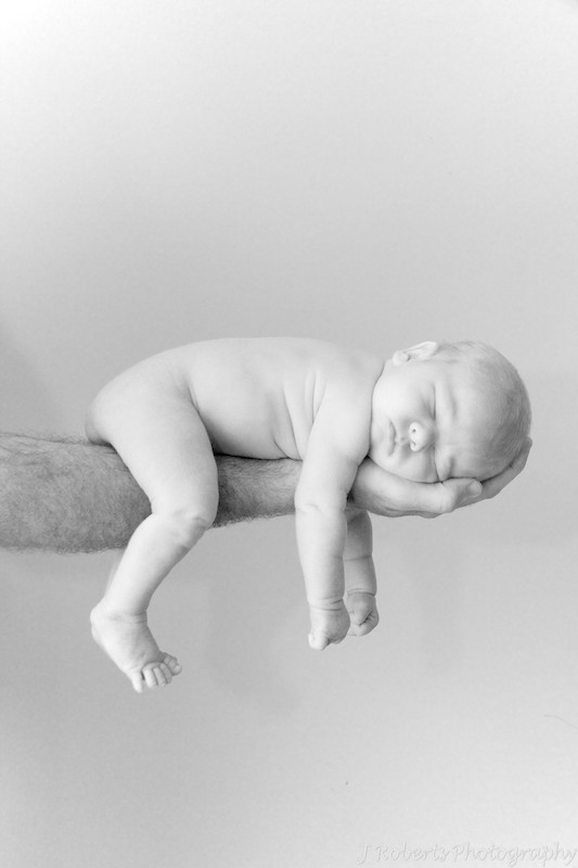 baby sleeping over fathers arm - newborn portrait photography